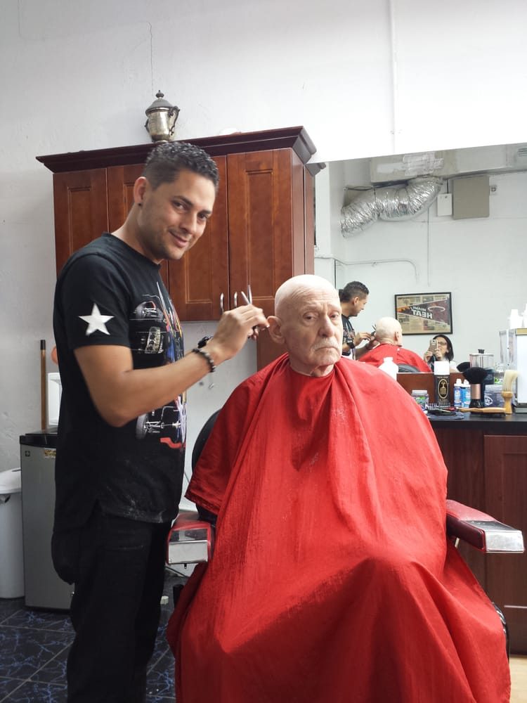Barbero cortándole el pelo a un cliente mayor en Shave Barbershop Miami Beach